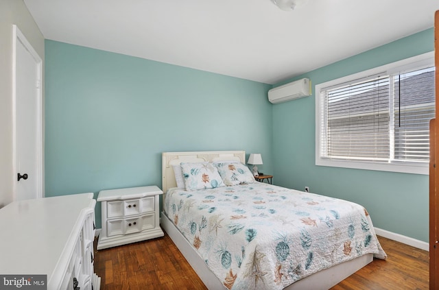 bedroom featuring a wall unit AC and dark hardwood / wood-style floors