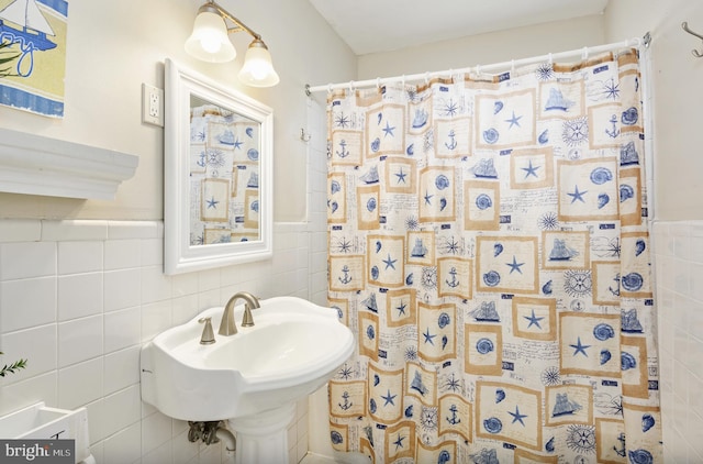 bathroom with a shower with shower curtain and tile walls