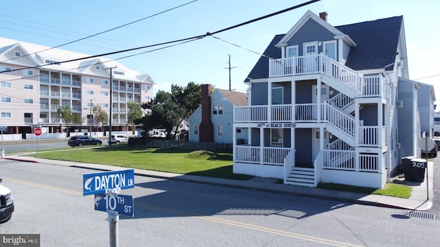 exterior space featuring a front lawn and a balcony