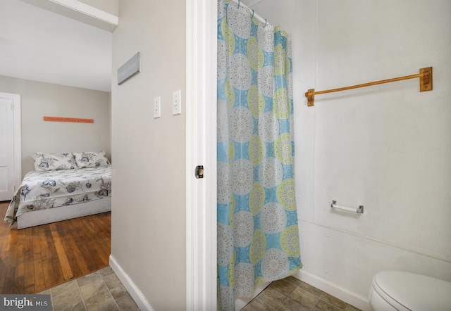 bathroom featuring wood-type flooring, a shower with shower curtain, and toilet