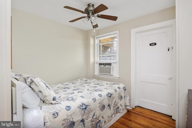 bedroom with ceiling fan, cooling unit, and hardwood / wood-style flooring