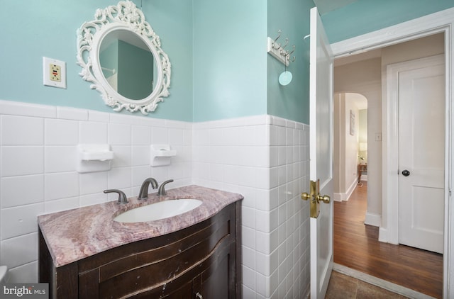 bathroom with tile walls, vanity, and wood-type flooring