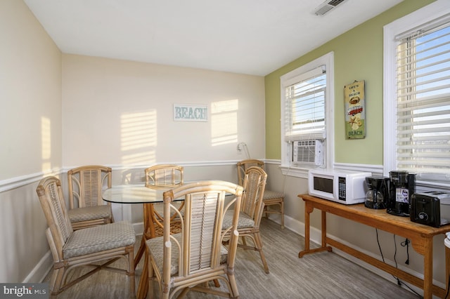 dining area featuring cooling unit and light hardwood / wood-style flooring