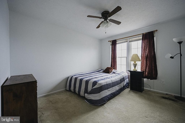 carpeted bedroom featuring a textured ceiling and ceiling fan