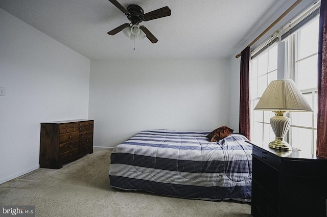 bedroom featuring ceiling fan and light carpet