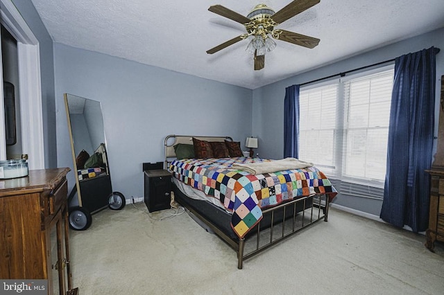 bedroom featuring carpet flooring, ceiling fan, and a textured ceiling