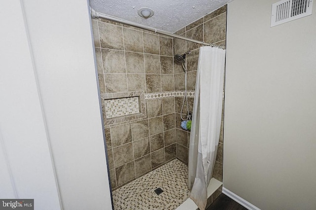 bathroom with a shower with curtain and a textured ceiling