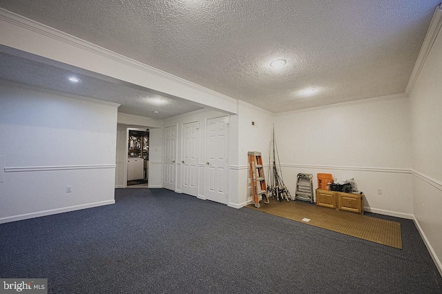 basement featuring dark carpet, crown molding, and a textured ceiling