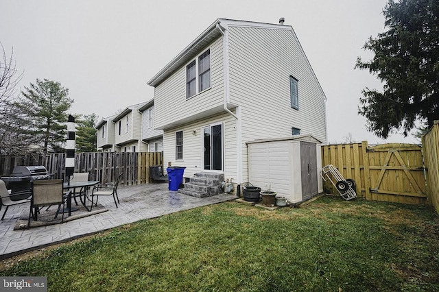 back of house featuring a shed, a yard, and a patio