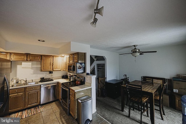 kitchen featuring sink, tile patterned flooring, ceiling fan, a textured ceiling, and appliances with stainless steel finishes