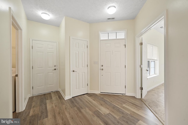 entrance foyer featuring a textured ceiling and wood-type flooring