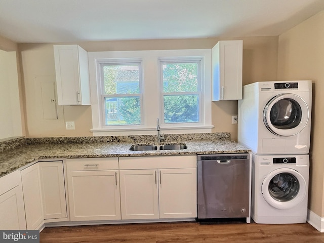 washroom with dark wood-type flooring, stacked washer and clothes dryer, and sink