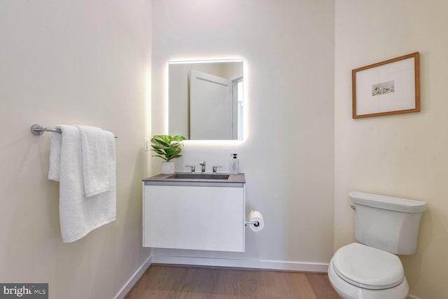 bathroom featuring hardwood / wood-style floors, vanity, and toilet