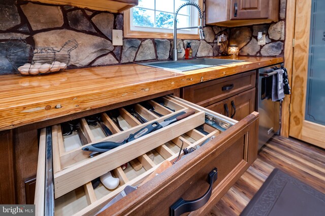 details with stainless steel dishwasher, hardwood / wood-style floors, and sink