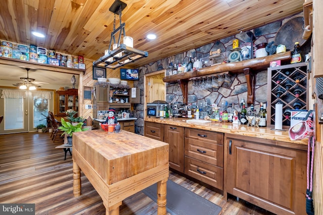 kitchen featuring ceiling fan, wood counters, dark hardwood / wood-style flooring, and hanging light fixtures