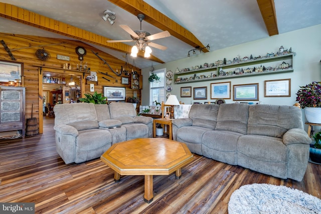 living room featuring wood walls, lofted ceiling with beams, and hardwood / wood-style floors