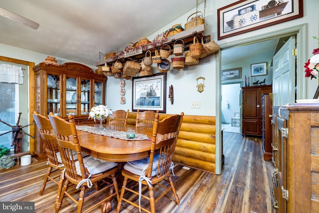 dining space featuring vaulted ceiling and dark hardwood / wood-style floors