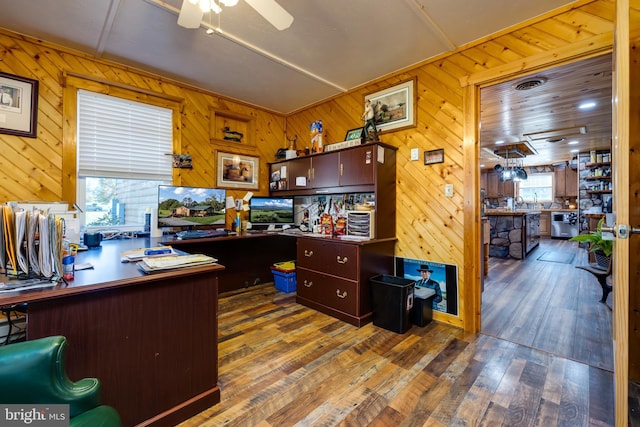 office space with wooden walls, dark hardwood / wood-style floors, and ceiling fan