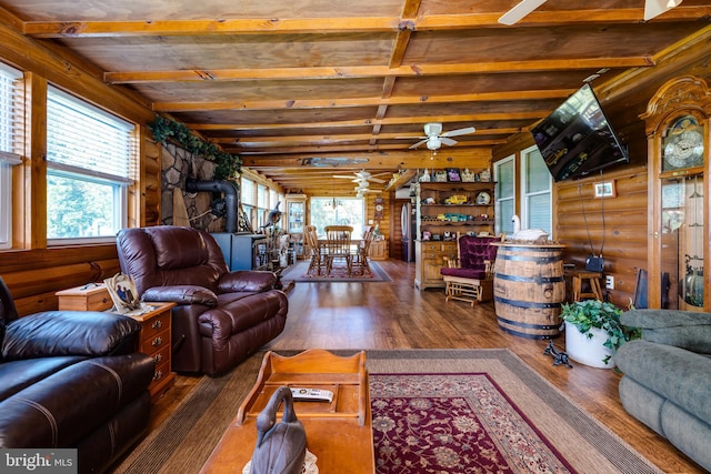 living room featuring ceiling fan, a healthy amount of sunlight, dark hardwood / wood-style flooring, and vaulted ceiling with beams