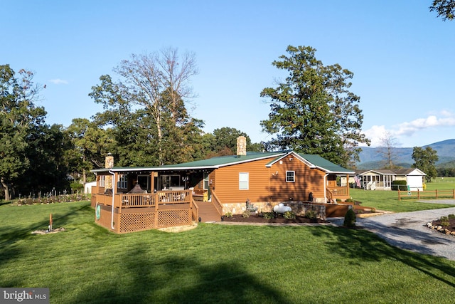 view of front of home featuring a wooden deck and a front lawn