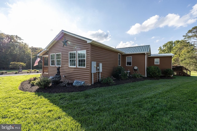 view of home's exterior featuring a wooden deck and a yard