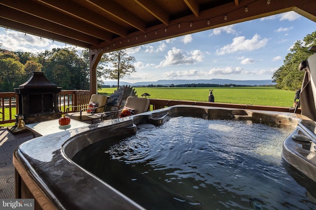 view of pool featuring a hot tub, a gazebo, a mountain view, and a rural view