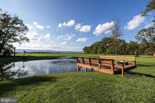 exterior space with a lawn and a water and mountain view