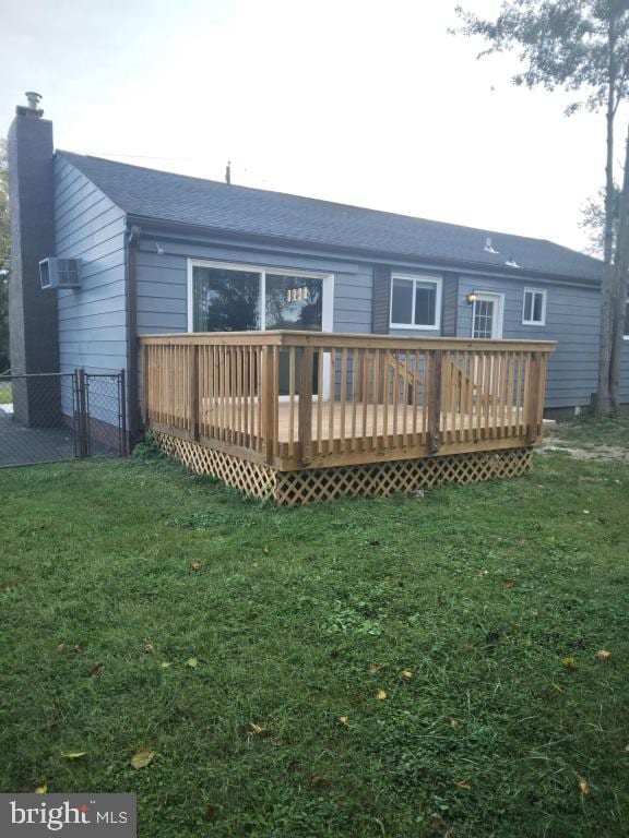 rear view of property with a wooden deck and a yard