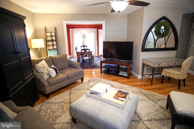 608 Cloverfields Dr, Stevensville, MD 21666 - living room featuring a chandelier, wood finished floors, ceiling fan, and baseboards