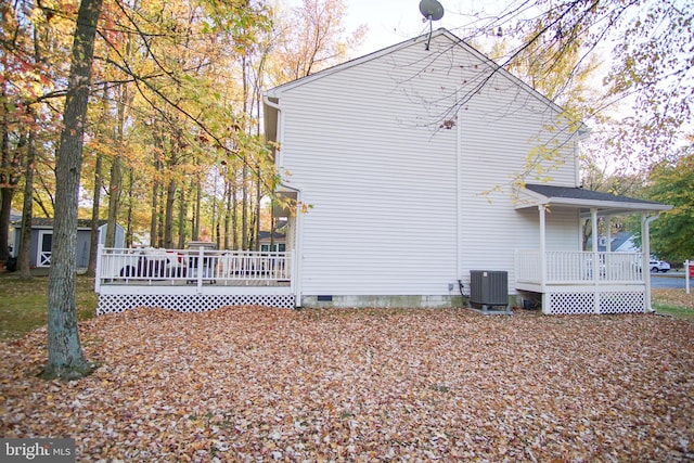 view of side of home with a deck and central AC unit