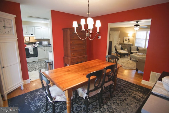 608 Cloverfields Dr, Stevensville, MD 21666 - dining room with a chandelier, light wood finished floors, and a ceiling fan