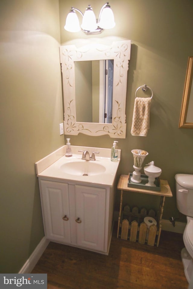 608 Cloverfields Dr, Stevensville, MD 21666 - bathroom featuring toilet, wood finished floors, vanity, and baseboards