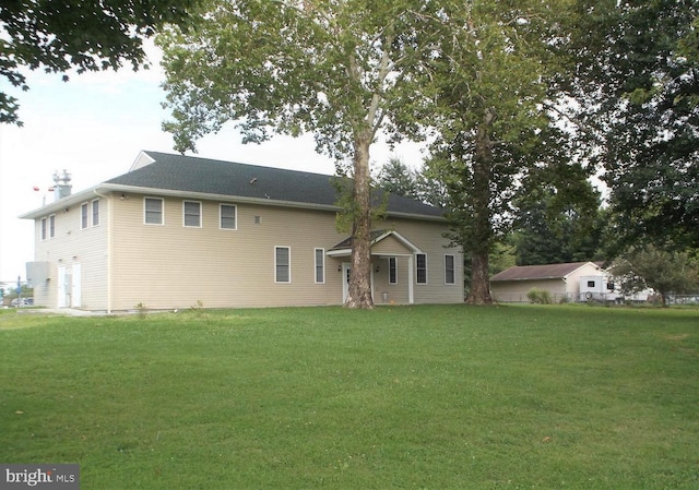 rear view of house featuring a yard