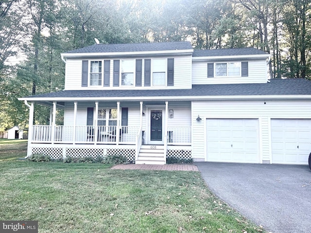 view of front of property with a front lawn, covered porch, and a garage