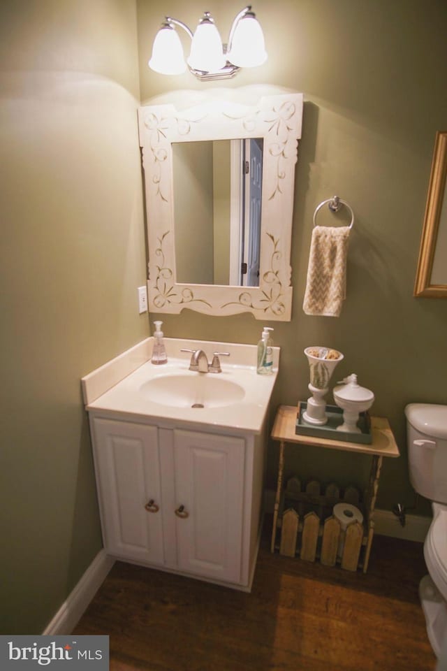 bathroom with vanity, toilet, and hardwood / wood-style floors