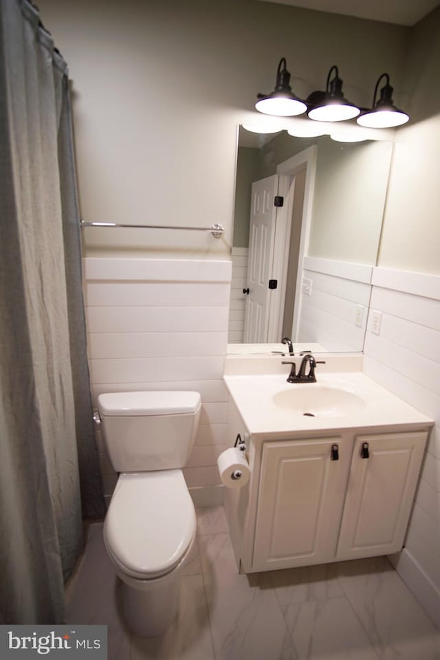 bathroom with vanity, toilet, tile walls, and a shower with curtain