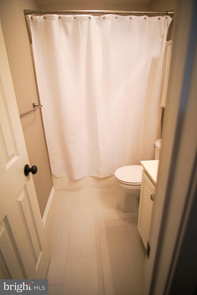 bathroom featuring vanity, toilet, and walk in shower