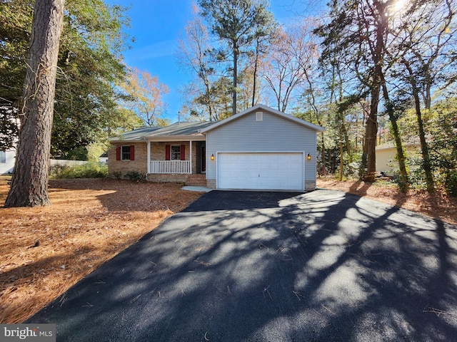 view of front of house featuring a garage, aphalt driveway, and covered porch