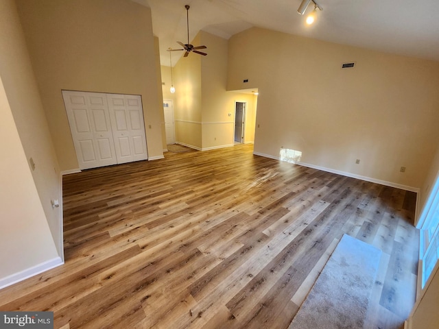 unfurnished living room with baseboards, high vaulted ceiling, wood finished floors, and a ceiling fan