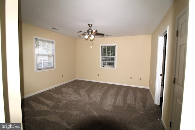 carpeted empty room with ceiling fan and a wealth of natural light