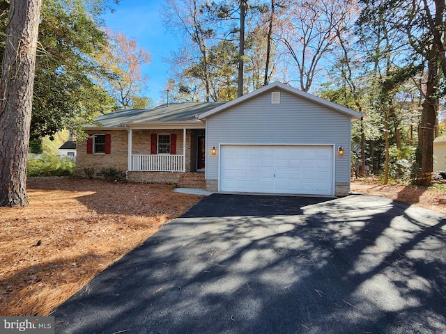 view of front of house with an attached garage, covered porch, and driveway