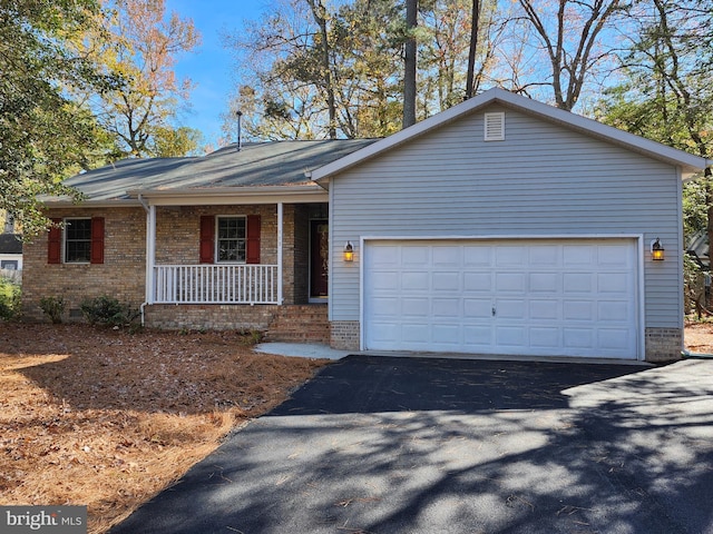 ranch-style house with a garage, brick siding, driveway, and covered porch