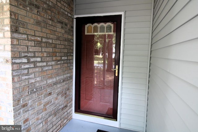 property entrance featuring brick siding
