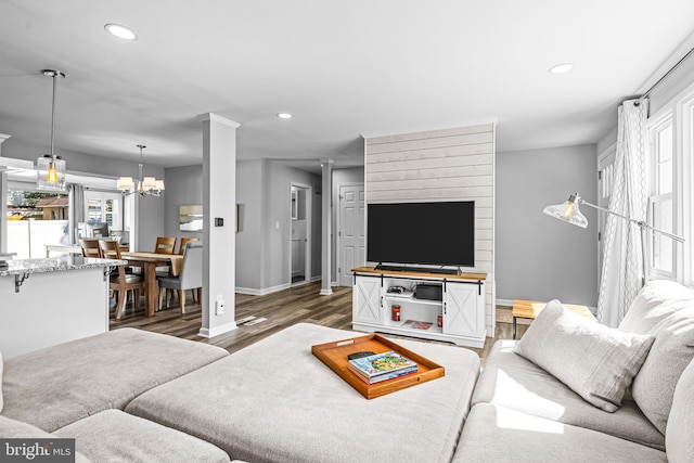 living room with dark hardwood / wood-style floors and a notable chandelier