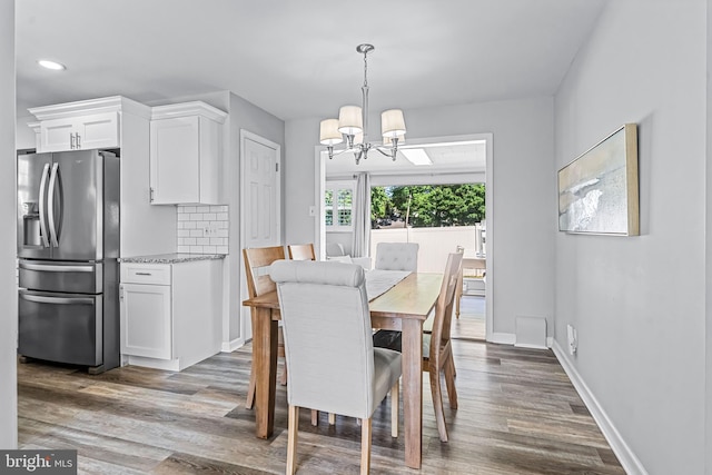 dining room with hardwood / wood-style flooring and a chandelier