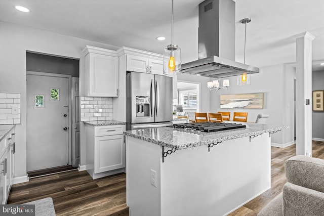 kitchen featuring island exhaust hood, a breakfast bar area, dark wood-type flooring, appliances with stainless steel finishes, and white cabinetry