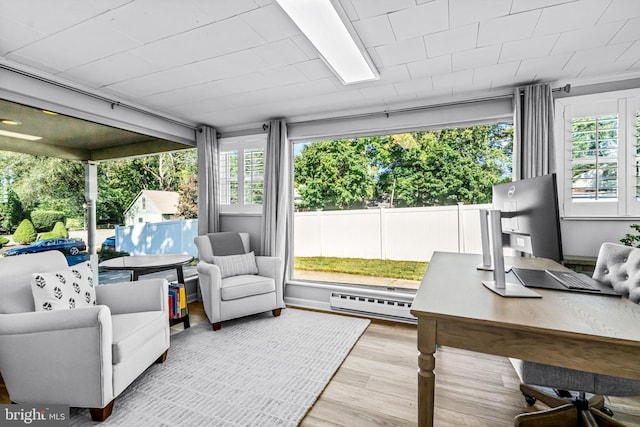 sunroom / solarium featuring plenty of natural light and baseboard heating