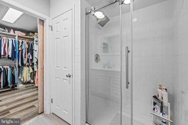 bathroom with a shower with door and hardwood / wood-style floors