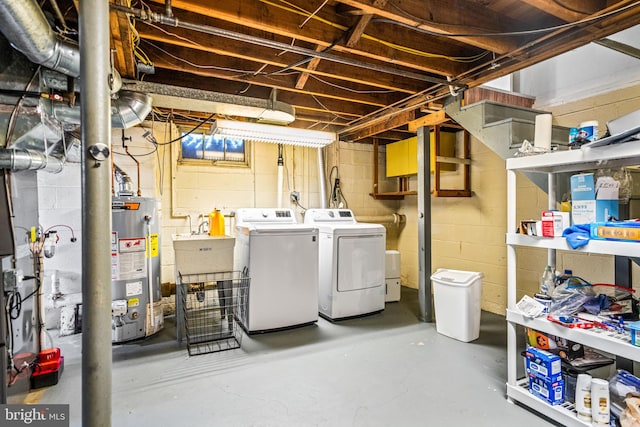 basement featuring washing machine and dryer and water heater