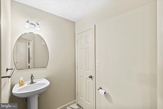 bathroom featuring a textured ceiling and sink